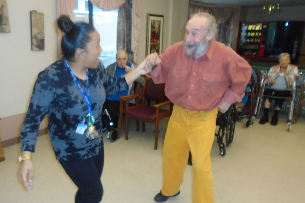 A staff member and resident having fun dancing